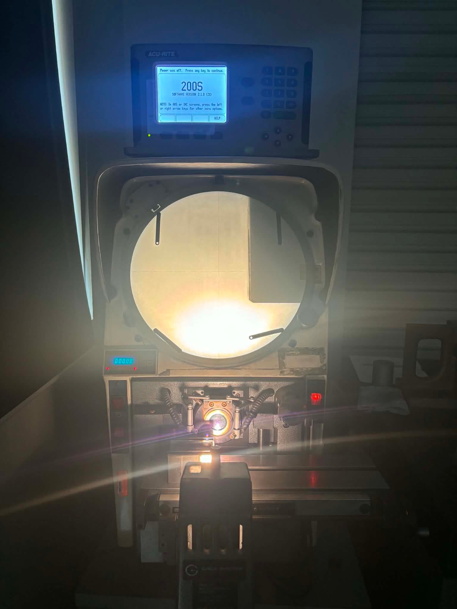 A part profile lit on the screen of the shop's optical comparator.